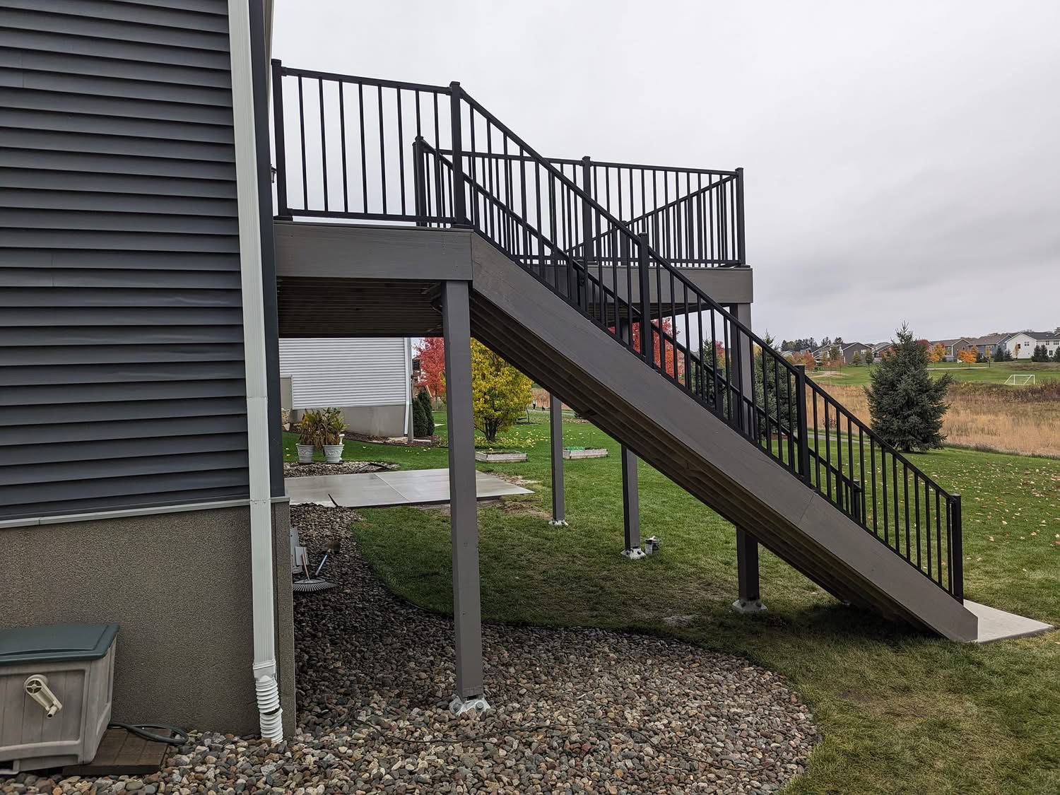 Elevated composite deck with long staircase and black aluminum railing