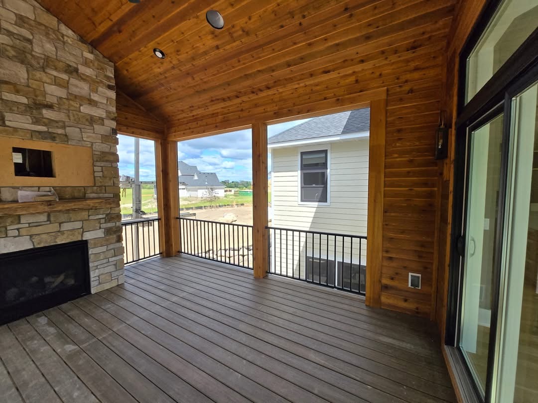 Deck'd Out LLC covered porch with cedar ceiling and stone fireplace